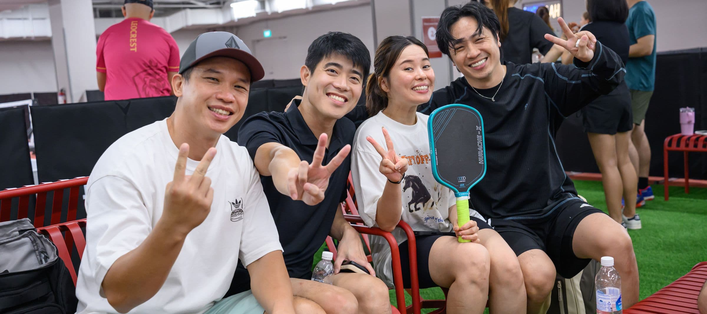 Four friends on the lounge benches making peace signs at the camera.